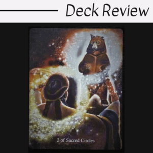 A tarot card from the Ancestral Path Tarot, titled 2 of Sacred Circles, shows a person with braided hair gazing at a glowing bear standing upright, holding a book amid magical, sparkling light.