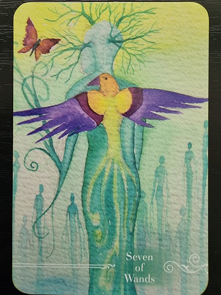 A colorful bird with purple and yellow wings spreads wide before a human figure with tree-like branches for hair. A butterfly flutters nearby, while shadowy silhouettes linger in the mist. Text reads Seven of Wands, inspired by the Guardian Tarot.