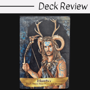 A tarot card from the Angels and Ancestors Oracle features a man with long hair, blue body paint, and large antlers, holding a staff. The card title reads Hunter: Track Down Your Fears and Desires. Deck Review is written above the card.