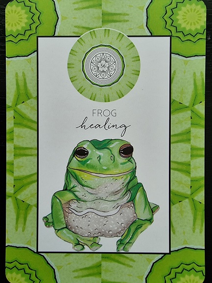 A card from the Animal Kin Oracle featuring a green frog illustration at the center, the words Frog Healing above it, and a geometric mandala pattern in shades of green as the background.