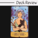 A tarot card from The Sasuraibito Tarot titled Queen of Wands shows a woman with short purple hair holding a black cat and a flowering wand, set against a blue and purple starry background. The words Deck Review appear above the card.