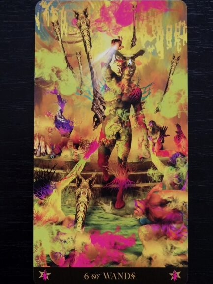 A vibrant Starman Tarot card titled 6 of Wands features a victorious figure in colorful, fantasy attire holding a wand, surrounded by vivid, swirling colors and fantastical creatures, suggesting triumph and celebration.