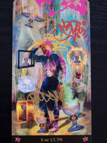 A colorful, surreal Starman Tarot 8 of Cups features a luminous figure surrounded by eight decorated cups, mystical symbols, pink and gold graffiti, and ethereal, dreamlike backgrounds.
