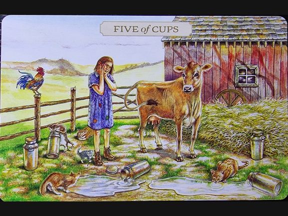 A girl in a blue dress cries by spilled milk cans as cats lick the spilled milk, with a cow nearby, a rooster on the fence, and a barn in the background. The card, part of the Pastoral Tarot deck, is labeled Five of Cups.