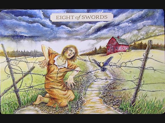 A distressed woman in an orange dress kneels on a rocky path, tangled in barbed wire. A black bird flies nearby. A red barn stands in the background under a stormy sky. The card, from Pastoral Tarot, reads Eight of Swords.