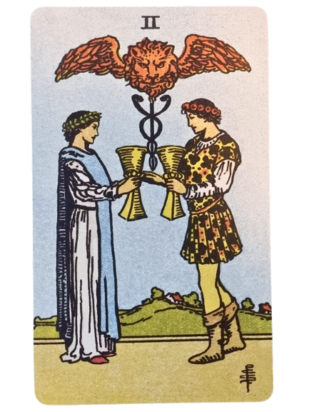 Two people stand facing each other, each holding a golden cup, their arms extended so the cups touch. Above them is a caduceus with a lion’s head and wings—a classic scene from Tarot: A Life Guided by the Cards—set against blue skies and green hills.