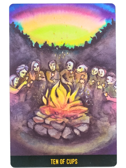 A group of people sit in a circle around a glowing campfire, raising cups and smiling under a vibrant, colorful sky. Trees form a dark silhouette in the background. The Penumbra Tarot card reads Ten of Cups at the bottom.