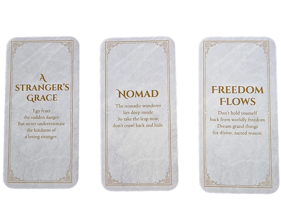 Three oracle cards from the Divine Doors series on a white background read: A Strangers Grace, Nomad, and Freedom Flows, each with a brief inspirational message beneath the title in gold lettering.