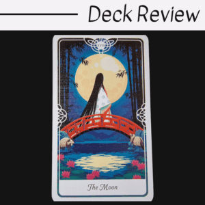 Tarot of the Divine’s The Moon card shows a figure in a kimono on a red bridge beneath a full moon, two white animals nearby, and water with lotus flowers below. Deck Review is displayed above.