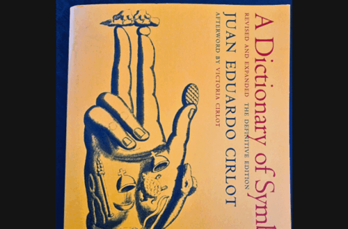 A book titled A Dictionary of Symbols by Juan Eduardo Cirlot with a yellow cover featuring an illustrated hand and small figures. Above the book is text that reads Book Review, highlighting A Dictionary of Symbols as the focus.