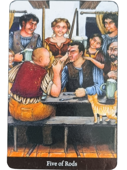 A group of five people gathers around a table, engaging in lively conversation that hints at the shifting energies of a new personal year. A woman and three men smile warmly as another man gestures animatedly. A cat stands nearby. The card is labeled Five of Rods.