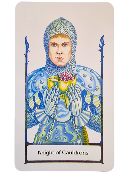 A Tarot of the Old Path card, the Knight of Cauldrons shows a knight in blue, patterned armor holding a golden cup filled with pink and white flowers, framed by a decorative border.
