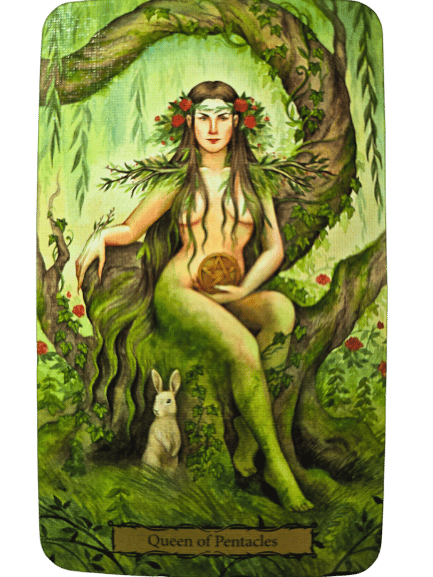 A woman dressed in leaves and flowers sits on a tree throne, holding a pentacle. Greenery and red flowers surround her, with a white rabbit at her feet. This Queen of Pentacles appears in the Tarot of the Witch's Garden deck.
