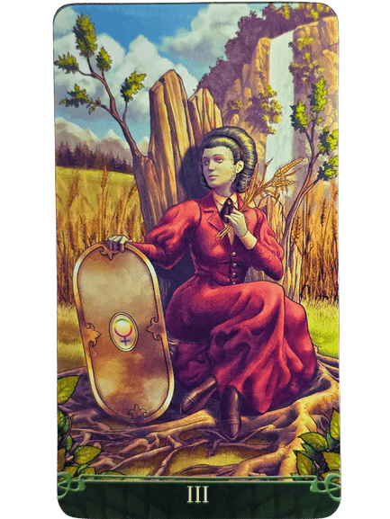 A woman in a red dress sits on the grass by a wooden post, holding a shield with a Venus symbol. She is surrounded by wheat, green plants, mountains, and a waterfall in this Tarot at the End of the Rainbow card marked with III at the bottom.