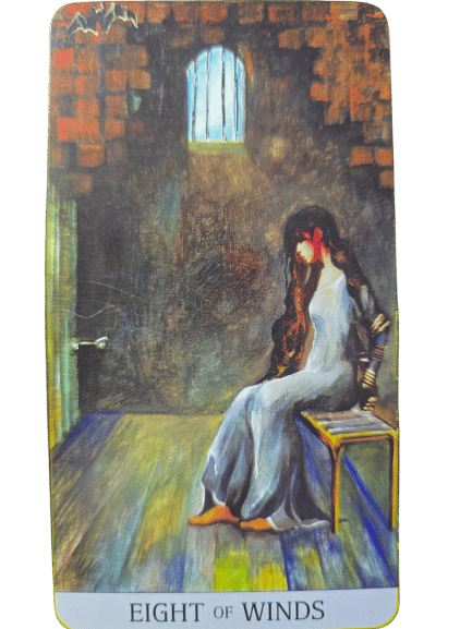 A woman in a long white dress sits on a bench in a dim, brick-walled room with barred windows. Her head is bowed, hands bound as light shines through. Inspired by Japaridze Tarot. Text below reads Eight of Winds.