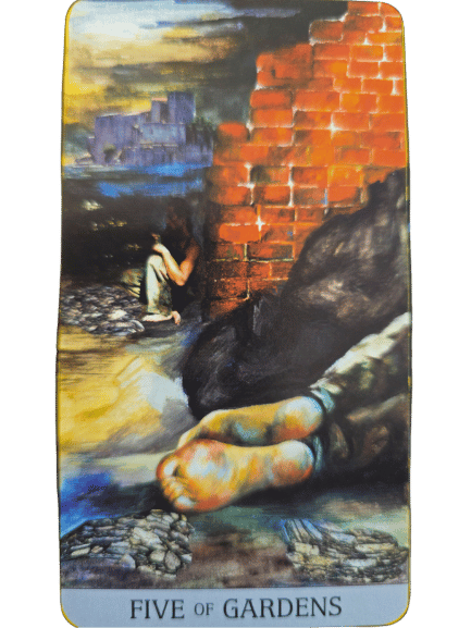 A Japaridze Tarot card, the Five of Gardens, depicts a barefoot person sitting near a crumbling brick wall, knees drawn up and head bowed, surrounded by rocks and a distant, gloomy building.
