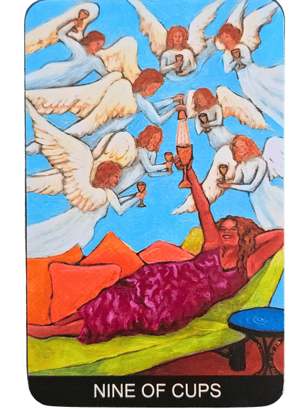 A woman in a purple dress lounges on a green sofa, joyfully raising a cup. Several angels with cups fly above her against a blue sky. The card reads Nine of Cups at the bottom, from the Tarot de St. Croix deck.