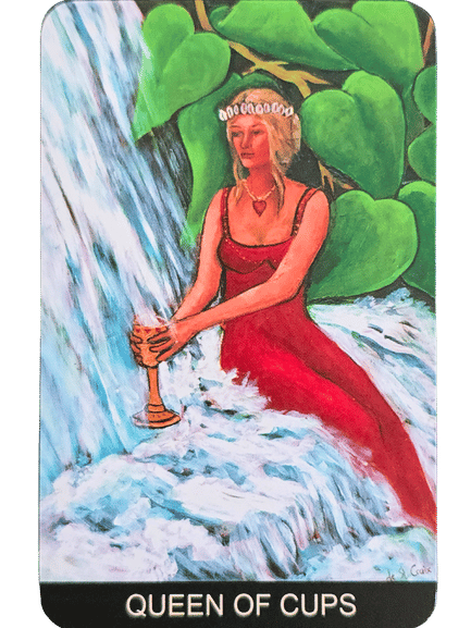 A woman in a red dress and crown sits by a flowing waterfall, holding a golden cup. Surrounded by lush green leaves and water, she embodies the serene spirit of the Tarot de St. Croix. The card is labeled QUEEN OF CUPS at the bottom.