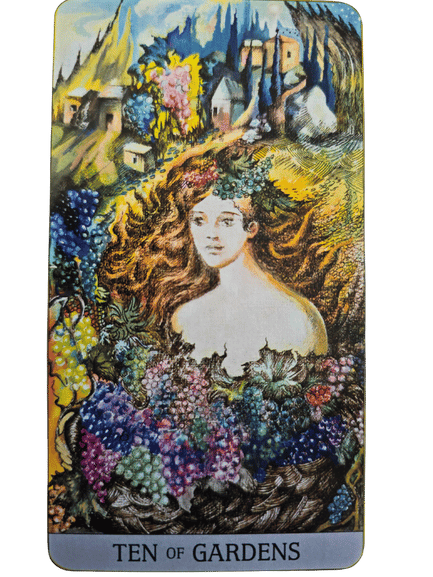 A colorful Japaridze Tarot card labeled Ten of Gardens features a serene woman with long hair surrounded by abundant grapes and lush foliage, with a vibrant village and rolling hills in the background.